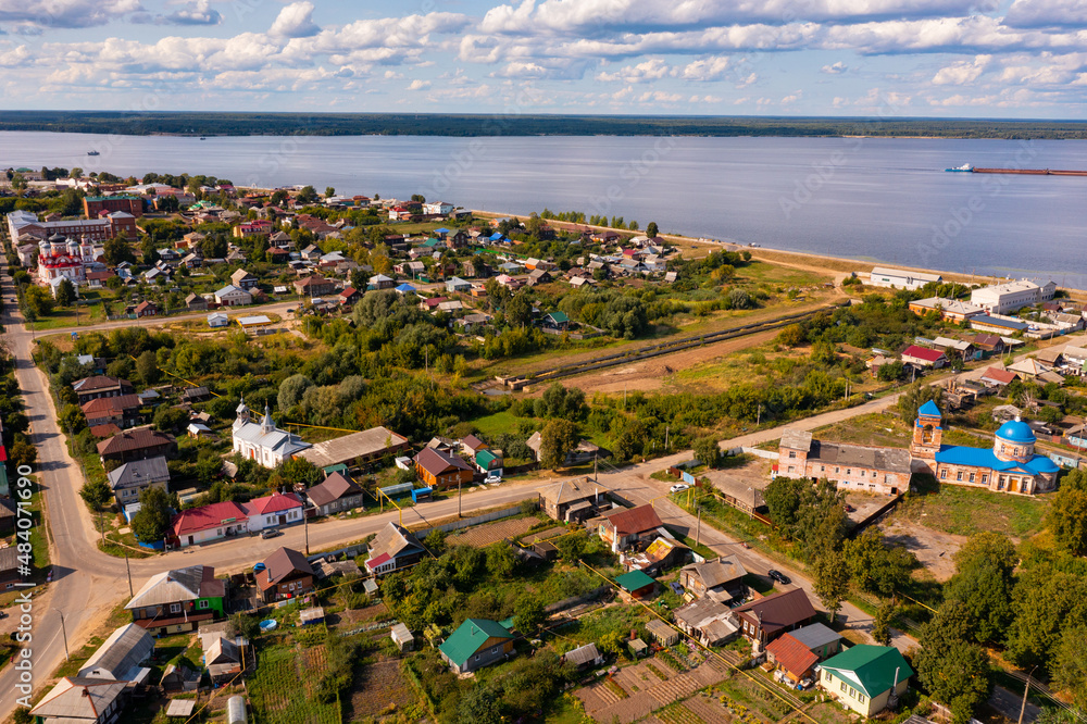 General aerial view of Kozmodemyansk townscape on banks of Volga River on sunny summer day, Mari El Republic, Russia