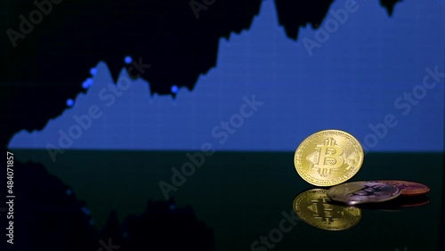 Three physical bitcoin coins on a reflective black surface, with a price rising up chart