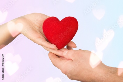 Happy volunteer holding red heart, promoting charity, donation campaign