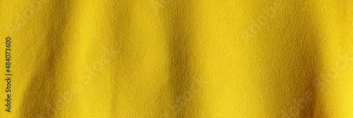 Fabric background with a yellow fabric cloth polyester texture. Wide banner