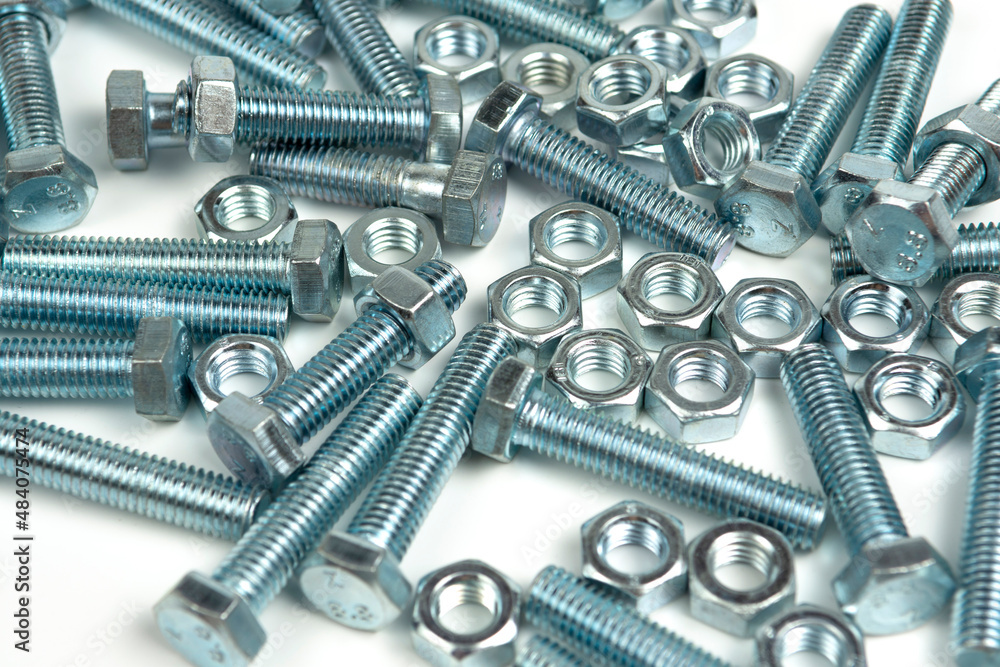 several silver metal bolts with nuts on a white background. close-up several silver metal bolts with nuts on a white background. close-up