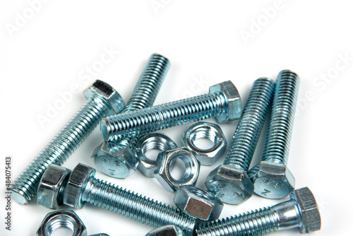 several silver metal bolts with nuts on a white background. close-up