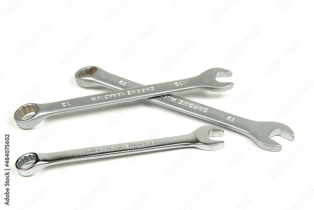 a group of new metal wrenches for tightening bolts and nuts on a white background a group of new metal wrenches for tightening bolts and nuts on a white background