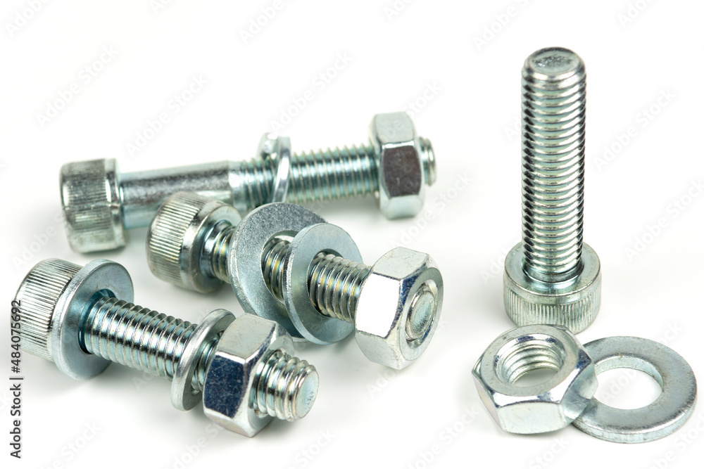 several metal washers, nuts and bolts of silver color on a white background. close-up several metal washers, nuts and bolts of silver color on a white background. close-up