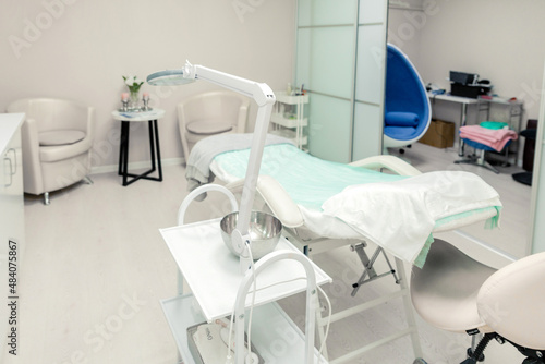 Cosmetologist empty office with care cosmetics and massage table in a modern beauty salon.