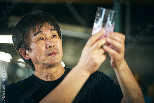 グラスの出来栄えを見るガラス職人 photo