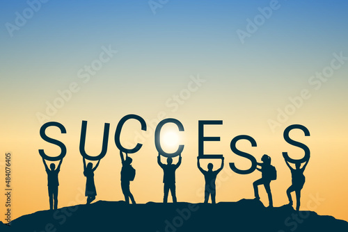 Success concept, silhouette of a group of people standing and holding signs combining with the word success. photo