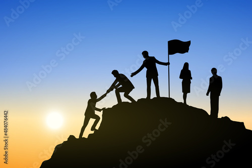 Silhouette of people helping each other hike up a mountain at sunrise. Business, teamwork, goal, success and help concept.