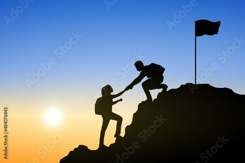 Silhouette of people helping each other hike up a mountain at sunrise. Business, teamwork, goal, success and help concept.