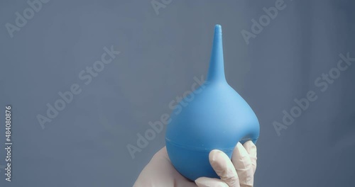 The hand shows the enema pear close up.