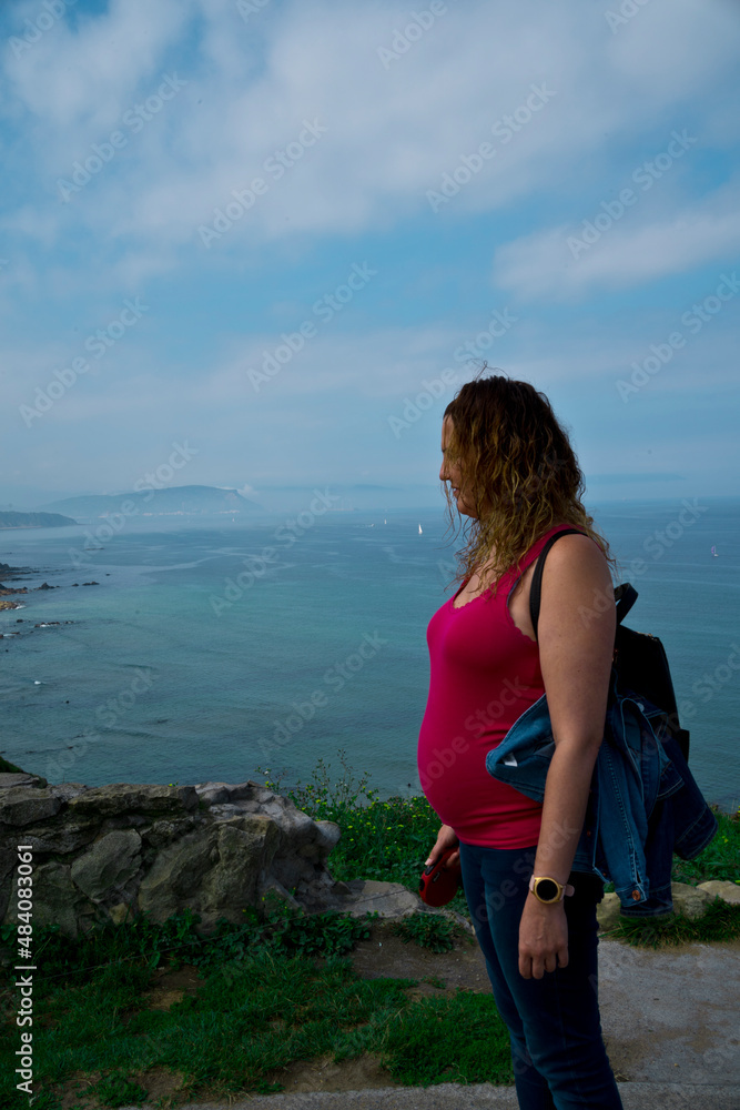 pregnant young woman posing by the sea