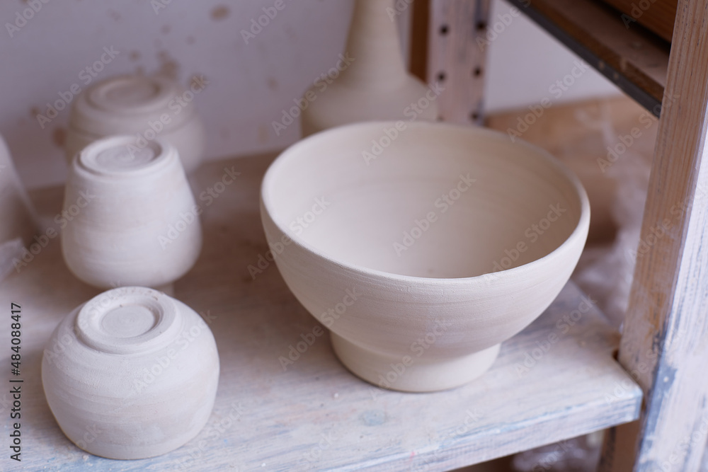 Empty handmade dishes. ceramic bowls on the shelf. Handmade work. The plates are made of clay