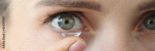 Fotografía Soft contact lens on female finger against background of female eyes
