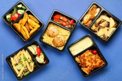 Takeaway boxes with tasty food on color background