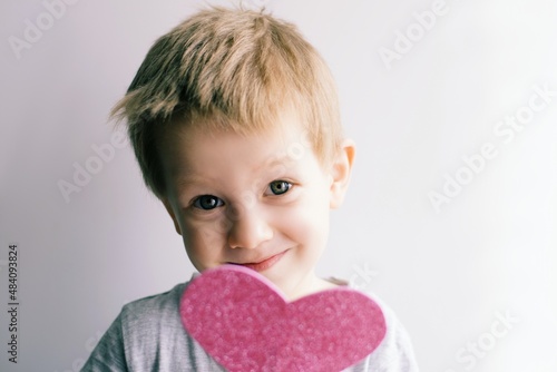 little emotional, smiling child with a pink heart