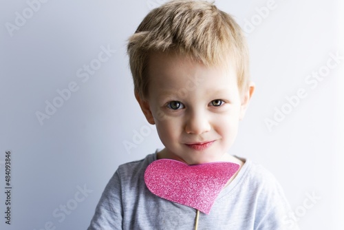 little emotional, smiling child with a pink heart