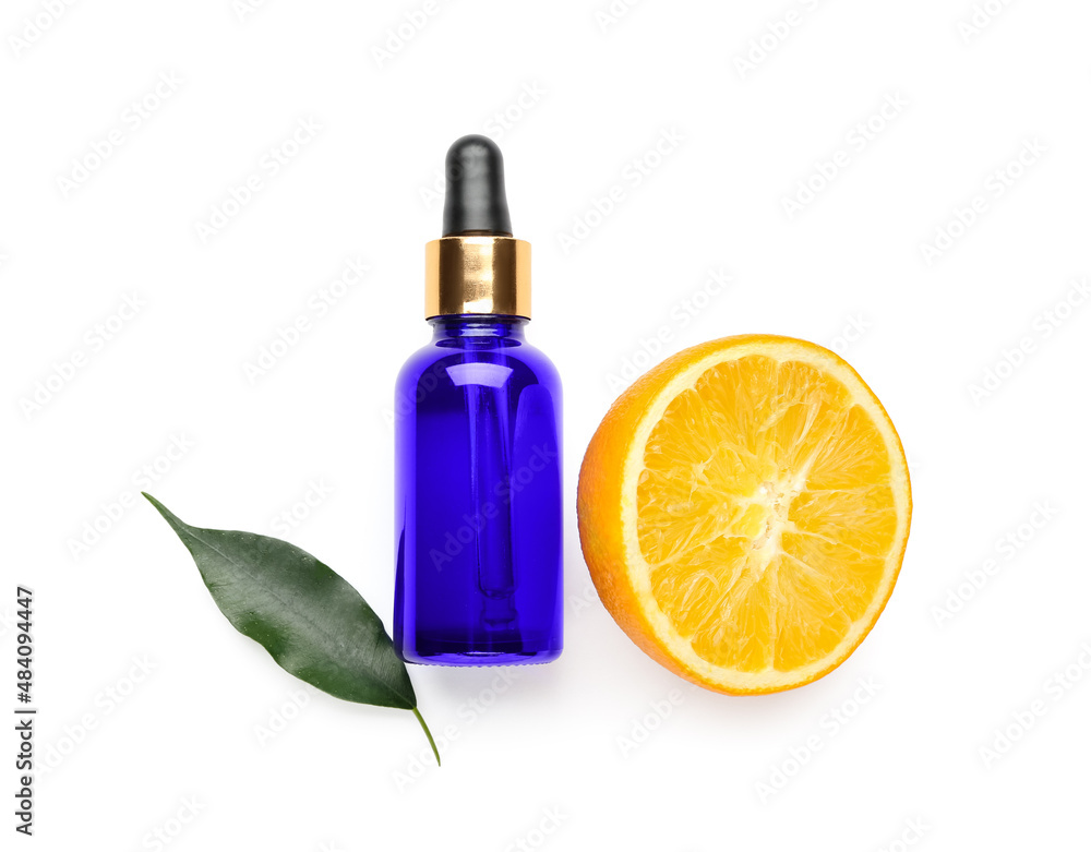 Bottle of essential oil and fresh cut orange on white background Bottle of essential oil and fresh cut orange on white background