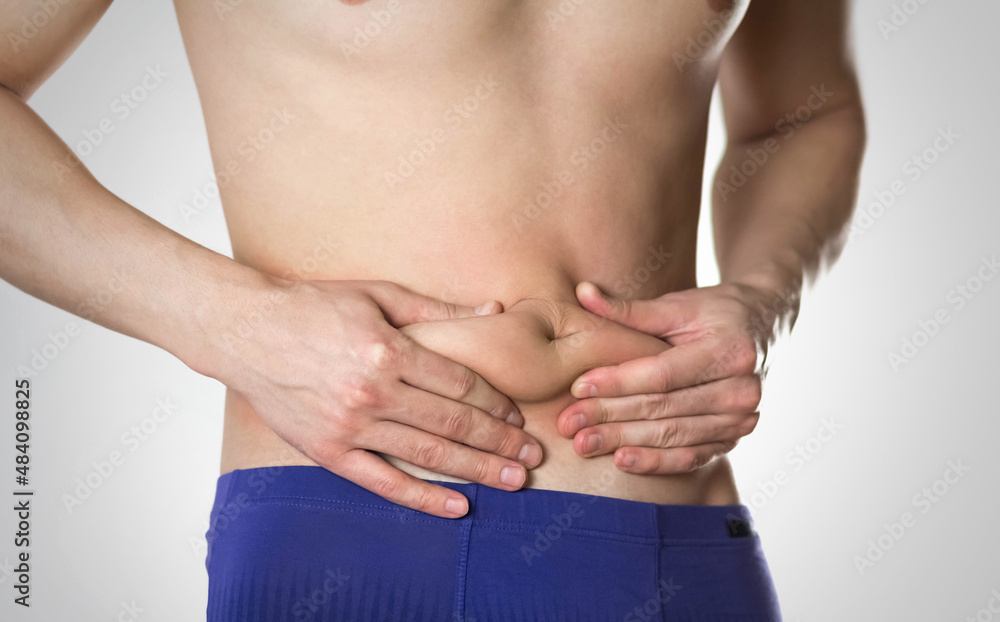 Fototapeta premium Weight loss. A man with overweight on his stomach