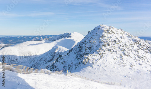 Valley of hilghland mountain winter resort on bright sunny day. Panoramic wide view of downhill slopes