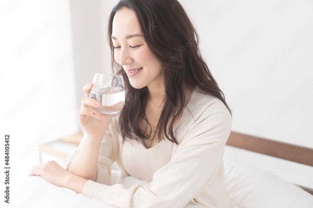 寝室で水を飲む女性 寝室で水を飲む女性