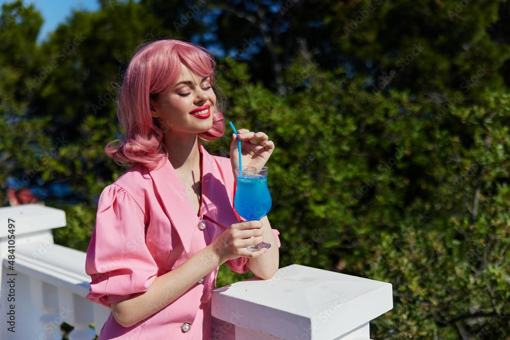 Young female in pink dress outdoors with cocktail Relaxation concept