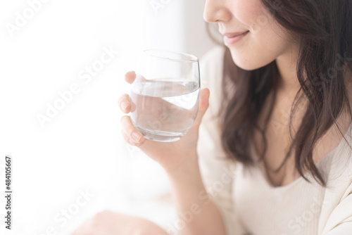 グラスに入った水を飲む日本人女性