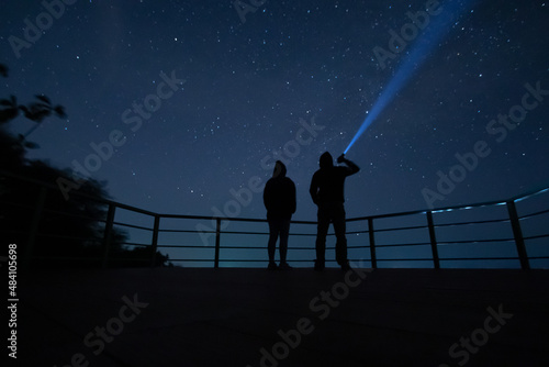 couple looking at the sky man holding a flashlight take looking at the night sky