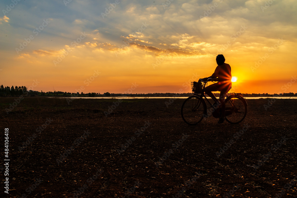 Fototapeta premium silhouette of people riding bicycles during sunset