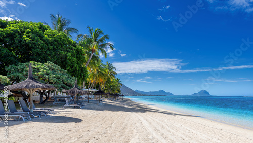 Obraz na plátně Paradise beach resort with palm trees and straw umbrellas and tropical sea in Mauritius island