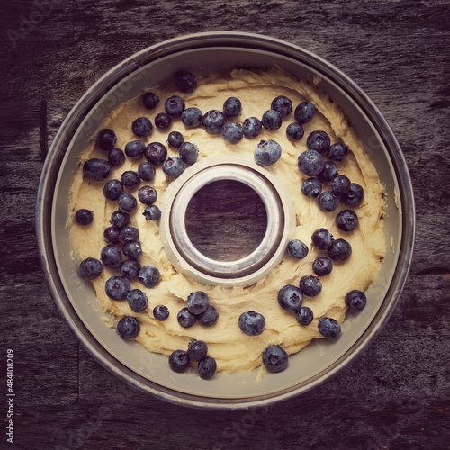 Vanillekuchen Rührteig mit Blaubeeren in einer runden Backform photo