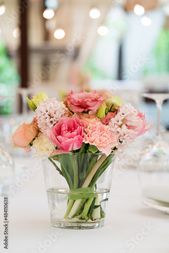 Flower table decorations for holidays and wedding dinner. Table set for holiday, event, party or wedding reception in outdoor restaurant.