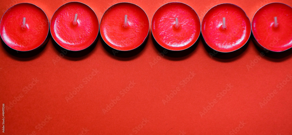 Red small candles on a red background with space for text Red small candles on a red background with space for text