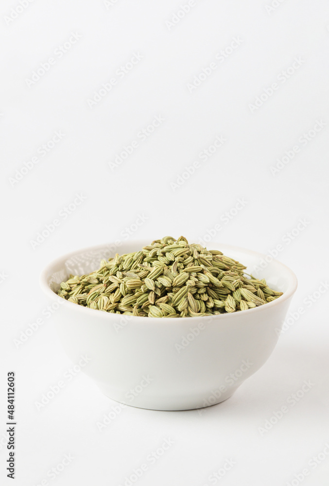 Green aromatic fennel seeds in the ceramic bowl on white background. Fennel is ingredient of traditional Indian cuisine Ayurvedic nutrition Green aromatic fennel seeds in the ceramic bowl on white background. Fennel is ingredient of traditional Indian cuisine Ayurvedic nutrition