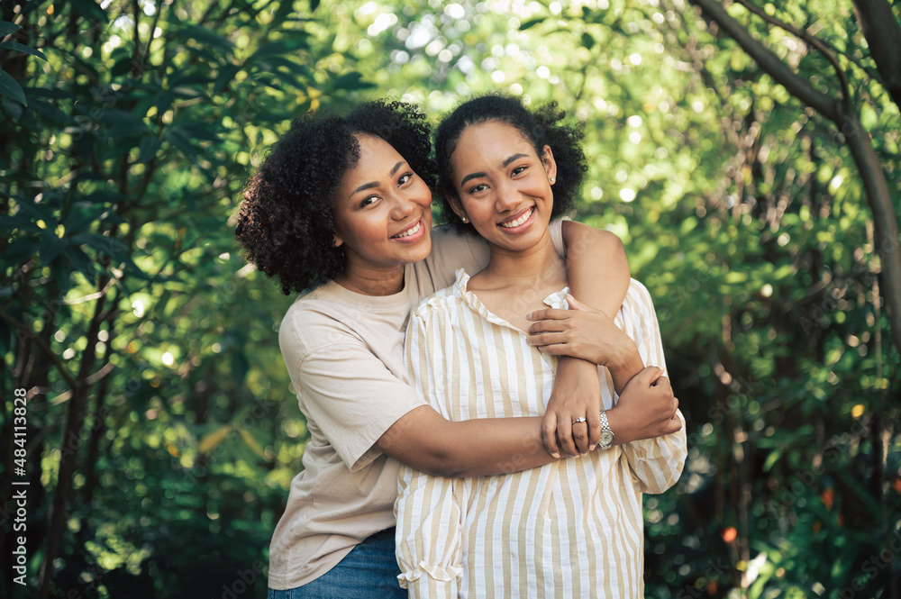 Friendship two young beautiful smiling girls and hugging in the garden Friendship two young beautiful smiling girls and hugging in the garden