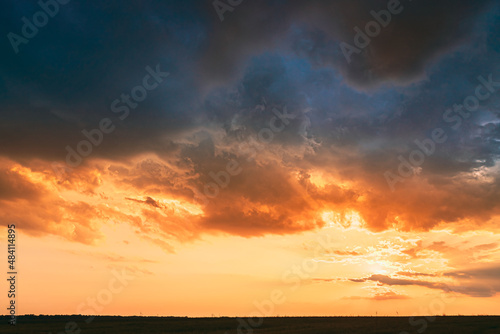 Meadow At Sunset Sunrise. Natural Bright Dramatic Sky In Different Colours Above Countryside Meadow Landscape. Agricultural Landscape In May.Meadow At Sunset Sunrise. Natural Bright Dramatic Sky In