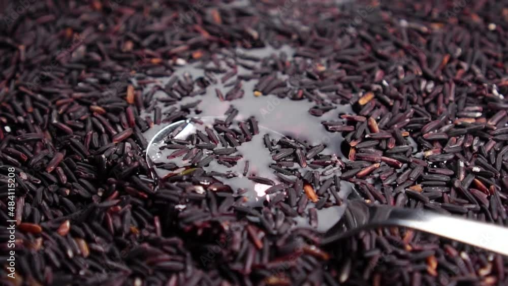 Cooking wild rice. Spoon in water with wet seeds. Stir grains in slow motion. Close-up. Rotation. Preparing Asian food Cooking wild rice. Spoon in water with wet seeds. Stir grains in slow motion. Close-up. Rotation. Preparing Asian food