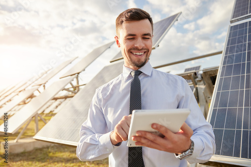 Bild auf Leinwand Cheerful businessman using tablet on solar farm