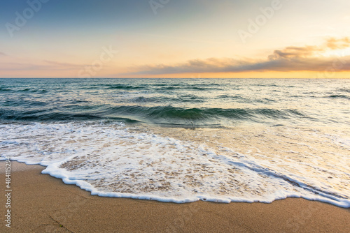 golden sand on the beach in summer. beautiful glowing clouds above the horizon. panoramic seascape at sunrise. relaxing summer mood in morning light. vacation concept background