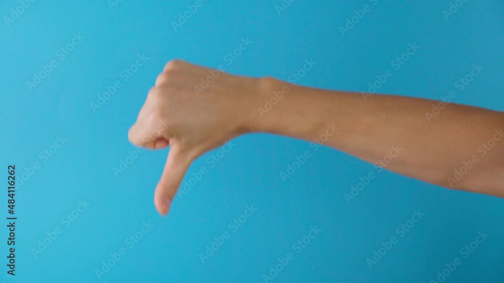 Hand thumb down on blue background. Rejection symbol. Copy space Hand thumb down on blue background. Rejection symbol. Copy space