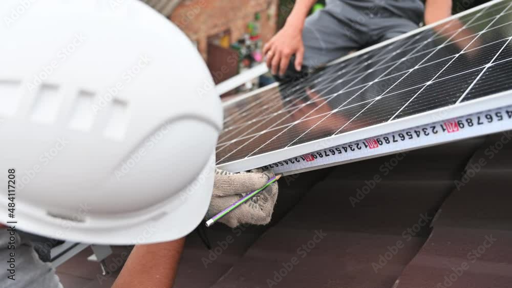 Man measuring photovoltaic solar panels with tape measure. Male worker ...