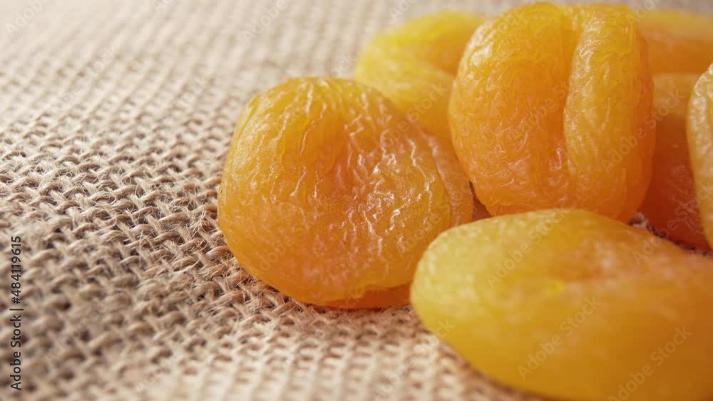 Dried apricots on a rustic burlap. Jerked dry fruits. Macro. Rotation. Healthy snack