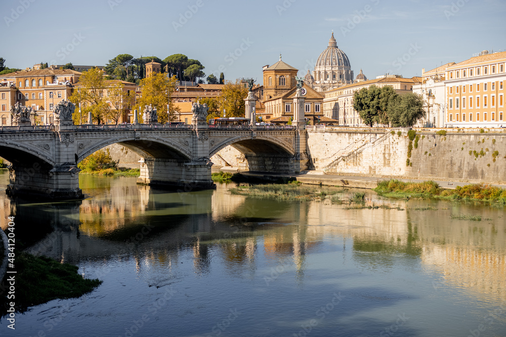 Landscape of Tiber river at sunny morning in Rome. Dome of famous saint Peter basalica on the skyline. Traveling Italy