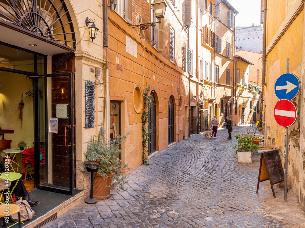 Narrow street with cafe and small shops in Rome. Italy travel concept, visiting cozy places