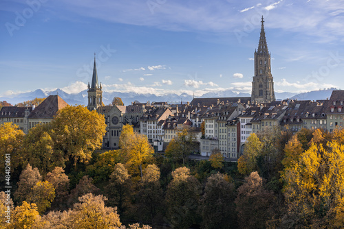 Bern im Herbst – Blick auf die Berner Altstadt und das Berner Münster. Am Horizont sieht man die Berge vom Berner Oberland.