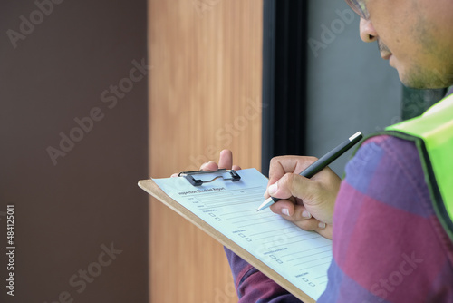 Worker Inspector or engineer is checking and inspecting the building or house by using checklist