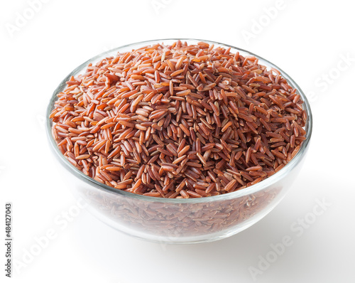 Uncooked red rice in glass bowl isolated on white background with clipping path