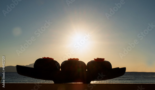 red candles in wooden candleholders on seaside in sunsire photo