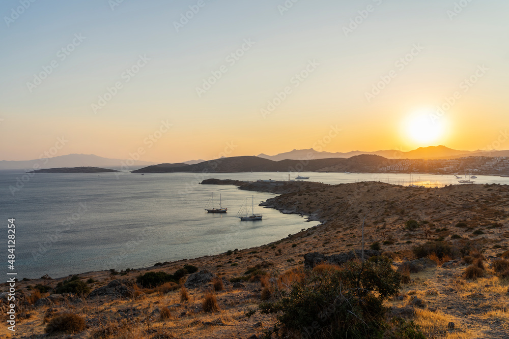 Magnificent landscape from the top point to the bay with yachts and the sun at sunset.