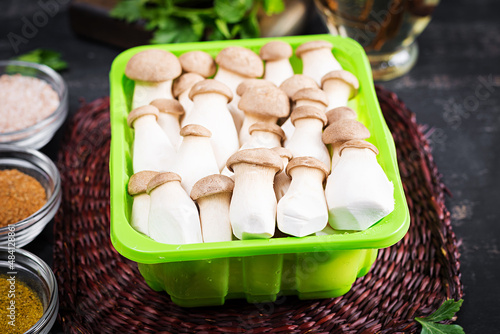 Raw king oyster mushrooms Pleurotus eryngii on a dark background photo