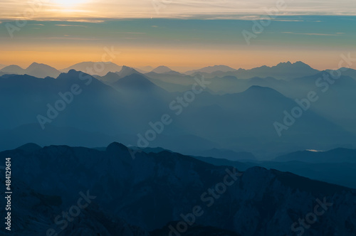 Layers of mountain ranges in Julian Alps at sunrise time in Slovenia viewed from the peak of Triglav